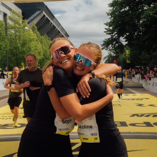 Two female runners hugging and smiling after finishing the Copenhagen Marathon